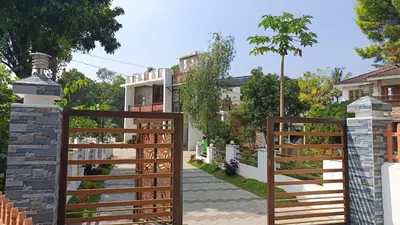 a wooden fence in front of a house at RiverBank Gardens, Mananthavady, Wayanad in Mananthavady