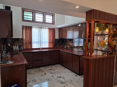 a large kitchen with wooden cabinets and a window at RiverBank Gardens, Mananthavady, Wayanad in Mananthavady