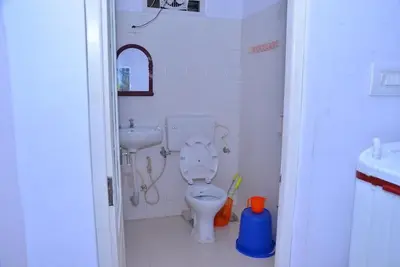 a bathroom with a toilet and a sink at Lead Homestay Chalakudy in Kizhake Chālakudi