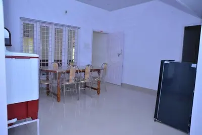 a dining room with a table and chairs at Lead Homestay Chalakudy in Kizhake Chālakudi