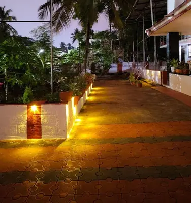 a pathway with lights on the side of a building at Lead Homestay Chalakudy in Kizhake Chālakudi