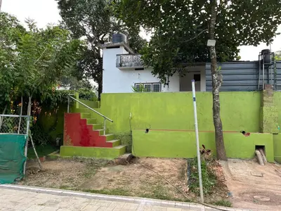 a house with a green and red wall and a staircase at Tulips villa in Mānantoddy