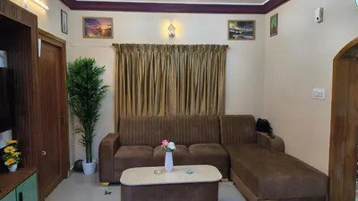 a living room with a couch and a table at Hideout luxe in Ooty