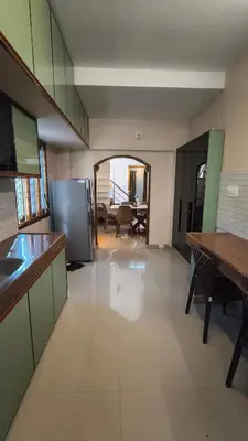 a large kitchen with a view of a living room at Hideout luxe in Ooty