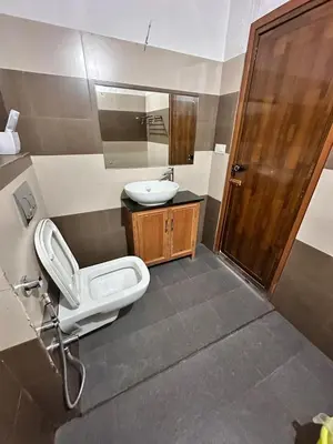 a bathroom with a sink and a toilet and a mirror at Avocado Orchards - Villa in Kenichira