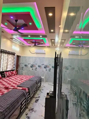 two beds in a room with neon lights at Happy Holidays Cottage in Wodapatti