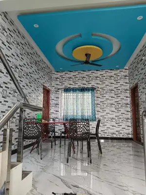a dining room with a blue ceiling and a table and chairs at Happy Holidays Cottage in Wodapatti