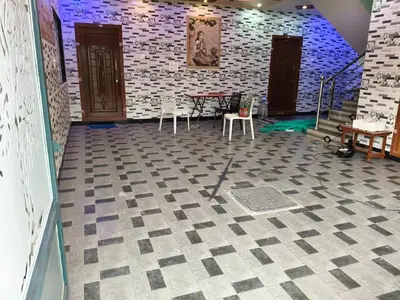 a room with a table and chairs on a checkered floor at Happy Holidays Cottage in Wodapatti