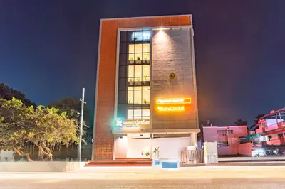 a tall brick building with a sign on it at Treebo Global Orchid in Mysore