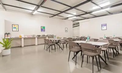 a dining room with tables and chairs and a counter at Treebo Global Orchid in Mysore