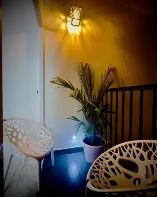 a room with a table and a chair and a plant at Tokyoz Inn Calicut in Kunnamangalam