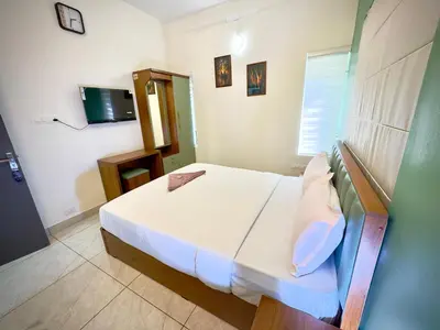 a bedroom with a bed and a television in it at Tokyoz Inn Calicut in Kunnamangalam