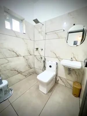 a bathroom with a toilet and a sink and a mirror at Tokyoz Inn Calicut in Kunnamangalam