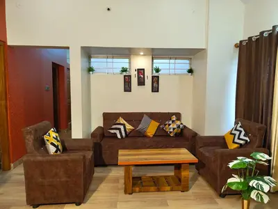 a living room with a couch and a coffee table at Galasy in Narasimharaja Puram