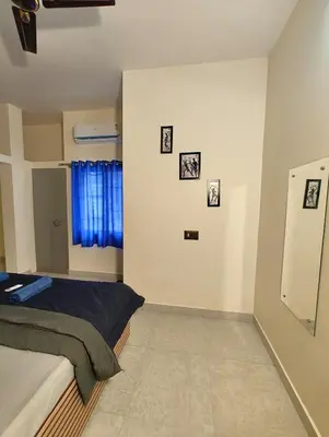 a bedroom with a bed and pictures on the wall at Galasy in Narasimharaja Puram