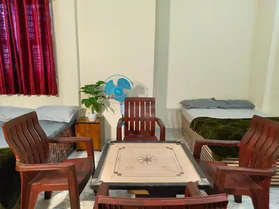 a room with two chairs and a table and a bed at Galasy in Narasimharaja Puram