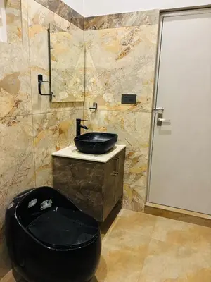 a bathroom with a black toilet and a sink at Hira Homestay Wayanad in Pinangode
