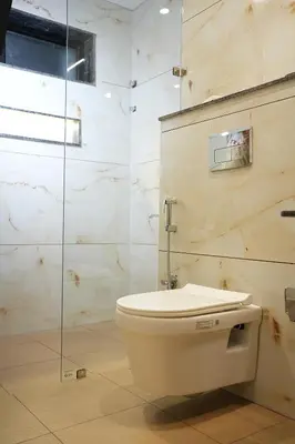 a bathroom with a toilet and a glass shower at Elite Group Mysore in Mysore