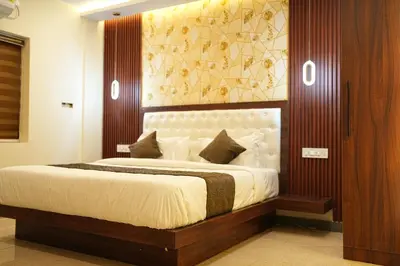 a bedroom with a large bed with a wooden headboard at Elite Group Mysore in Mysore