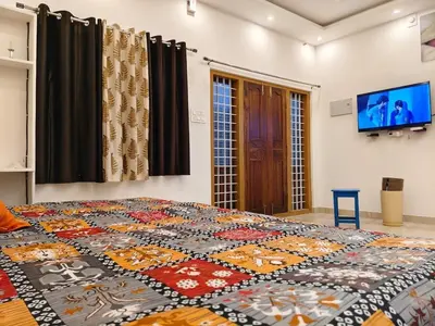 a bed in a room with a quilt on it at Hridayam Hill view nest in Marayoor