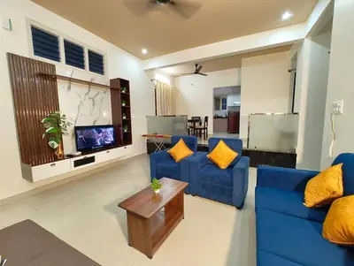 a living room with two blue couches and a tv at Namasv 2BHK AC House in Narasimharaja Puram