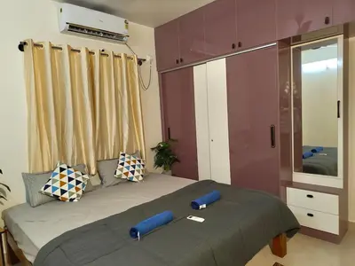 a bedroom with a bed with two pillows and a mirror at Namasv 2BHK AC House in Narasimharaja Puram