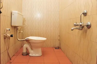 a bathroom with a toilet in a stall at Alfa Tourist Home, Batheri in Sultan Bathery