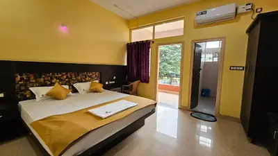 a bedroom with a large bed with yellow walls at Corcordium by ssr in Bilikere
