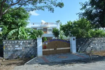 a dog standing in front of a fence at Brindavanam HomeStay Salem in Salem