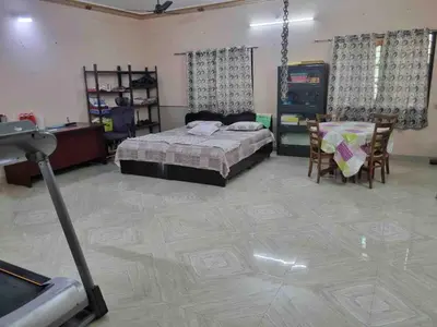 a bedroom with a bed and a table and chairs at Brindavanam HomeStay Salem in Salem