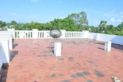 a balcony with a brick floor and a white fence at Brindavanam HomeStay Salem in Salem