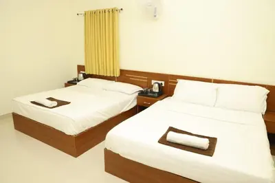 two beds in a hotel room with towels on them at The Dew Nest in Ooty