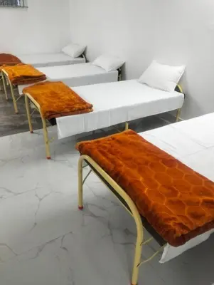 a row of beds in a room with orange seats at Prithivee Homestay in Kotagiri