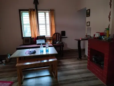 a living room with a table and a fireplace at Avichala in Mysore