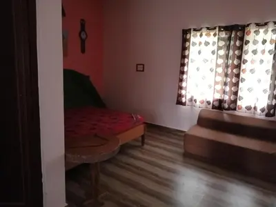 a living room with a couch and a window at Avichala in Mysore