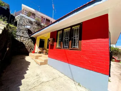 a red and yellow building with a window at Skyline Haven cottage ll in Ooty