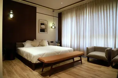 a bedroom with a bed and a couch and a chair at Hotel Aarka in Mettuppālaiyam