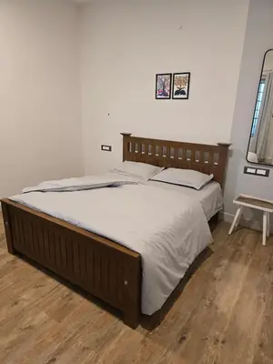 a large bed in a bedroom with a wooden headboard at The Brook by Turquoise Villas in Kodaikānāl