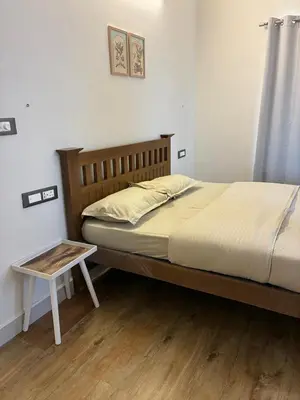 a bed with a wooden headboard and a table in a room at The Brook by Turquoise Villas in Kodaikānāl