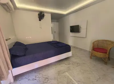 a bedroom with a bed and a tv and a chair at Mystic Rock Staycations in Mannārakkāt