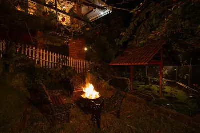 a fire pit in a yard at night at SaffronStays Oakridge Cottage in Coonoor