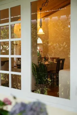a reflection of a dining table in a window at SaffronStays Oakridge Cottage in Coonoor
