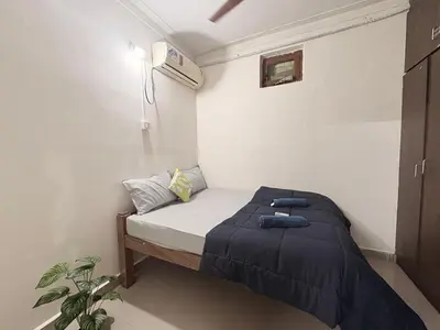a small bedroom with a bed with a blue blanket at Kamadhenu Homestay, Comapact 2BHK OPP Mysore zoo B in Mysore