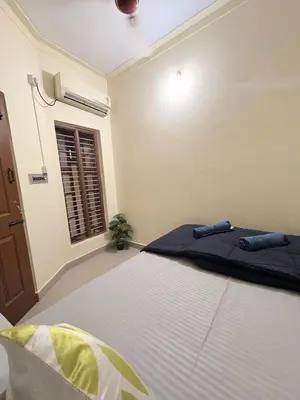 a bedroom with a bed and a window at Kamadhenu Homestay, Comapact 2BHK OPP Mysore zoo B in Mysore