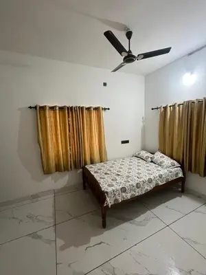 a bedroom with a bed and a ceiling fan at Idachirakkal homestay in Palghat