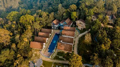 an aerial view of a house in the forest at Golf Valley Luxury Resort Wayanad in Vythiri