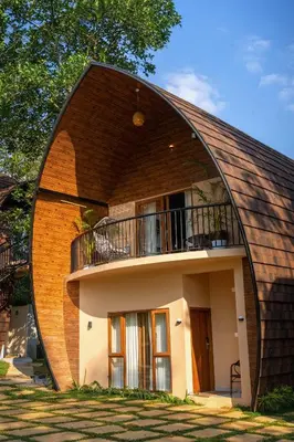 a circular house with a round roof at Golf Valley Luxury Resort Wayanad in Vythiri