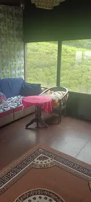 a room with a bed and a table and a window at Bison valley in Ooty
