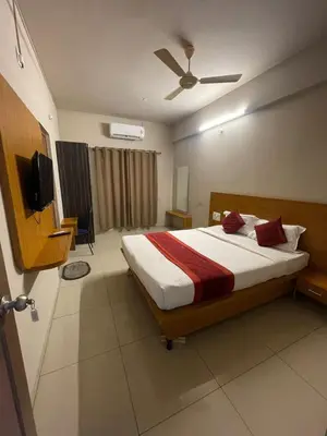 a bedroom with a bed and a flat screen tv at AAKI Comforts in Mysore
