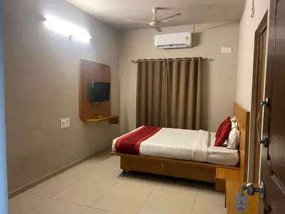 a bedroom with a bed and a tv in it at AAKI Comforts in Mysore